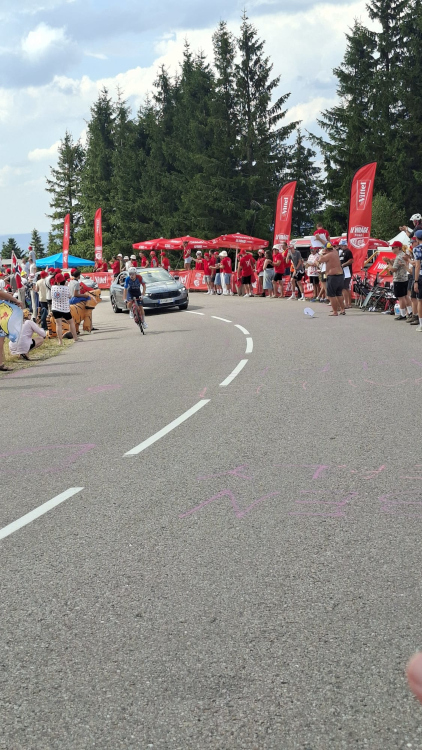 Les barrières personnalisées "Le Virage Vittel" — habillage continu en bord de route, visible depuis la chaussée et parfaitement lisible à l'image. Barrières personnalisées Vittel — vue linéaire avant passage des coureurs