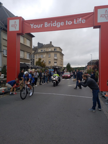 Arche rouge "Your Bridge to Life" au fil de passage, spectateurs, cohésion visuelle Arche rouge