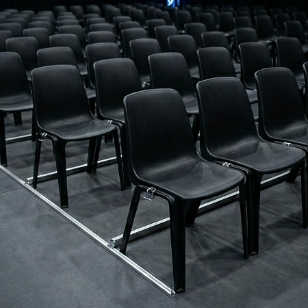 Des chaises pour une salle de meeting, séparées avec les barres inter-rangées indispensables en ERP Des chaises pour une salle de meeting, séparées avec les barres inter-rangées
